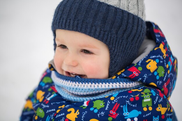 写真 冬の雪の中の小さな男の子。