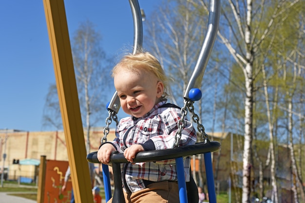 Photo small boy playing on child playground.