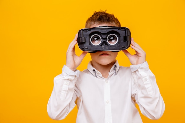 Small boy in white shirt looking at camera through virtual reality headset isolated