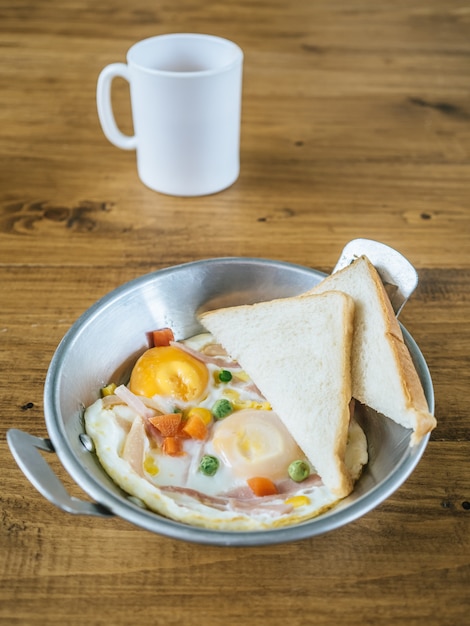 Foto piccola colazione a base di uova fritte e pane.