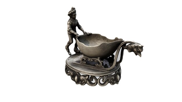 A small bronze figure of a man with a large bowl on it.