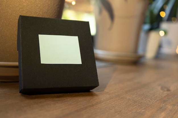 Small brown gift box with space for a logo on a wooden table close up
