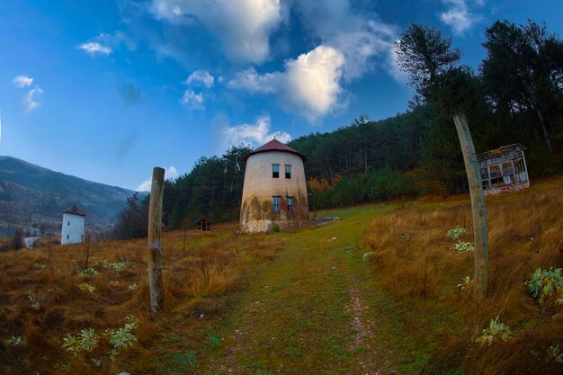 a small building is on the side of a dirt road