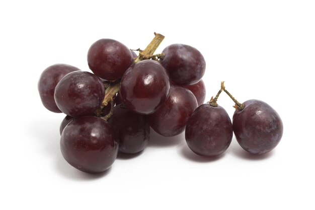 A small bunch of fresh organic red grapes delicious fruit isolated on white background clipping path