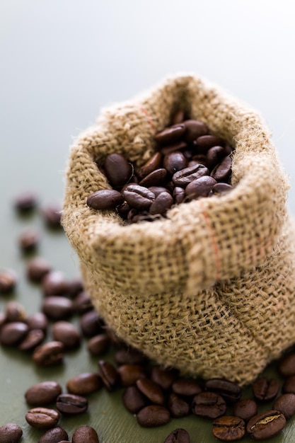 Small burlap bag filled to the top with coffee beans.