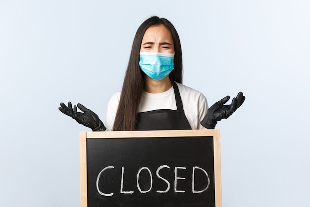 Small business, covid-19 pandemic, preventing virus and employees concept. Upset desperate cafe owner left without work and business during lockdown, crying over closed sign