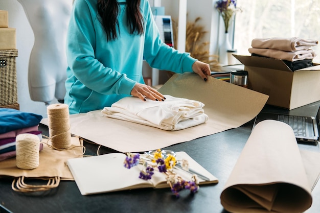 Small business owner woman packs the goods in eco packaging in office shop