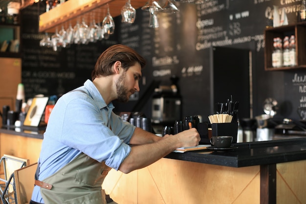 Foto piccolo imprenditore che lavora al suo caffè.