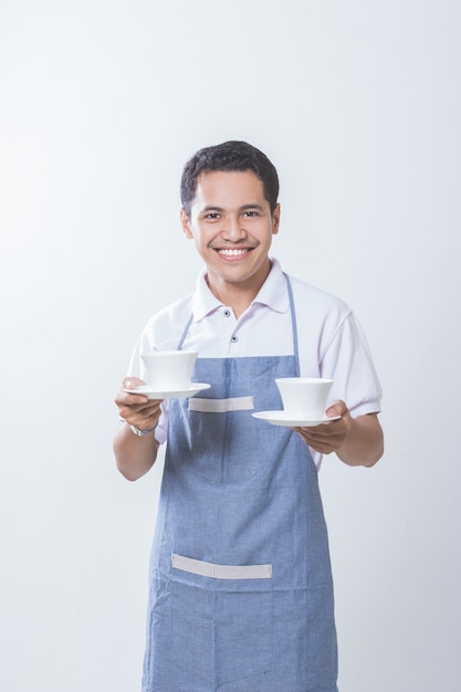 Proprietario di un piccolo negozio di caffè con due tazze di caffè