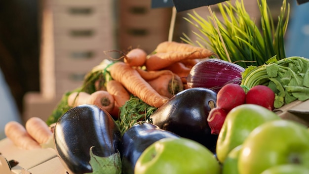 Small business shop with fruits and veggies grown in garden on display at outdoors market, seasonal harvest. Various vegetables and organic products sold in boxes. Handheld shot. Close up.