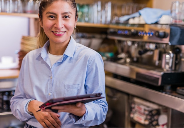 Small business woman owner using tablet technology young peruvian latinx bistro entrepreneur