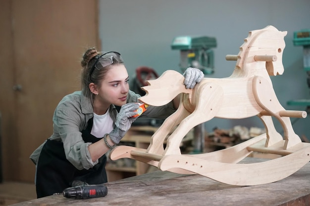 Малый бизнес молодой женщины Привлекательная молодая женщина-плотник-дизайнер работает в мастерской