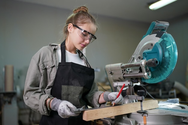 Piccola impresa di una giovane donna bella giovane donna lavoratore in un laboratorio di mobili di misurazione del legno