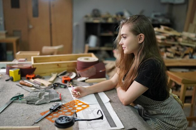 Photo small business of a young woman in furniture workshop background