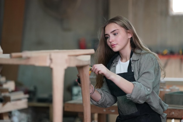 Малый бизнес молодой женщины на фоне мебельной мастерской
