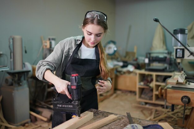 Small business of a young woman in furniture workshop background