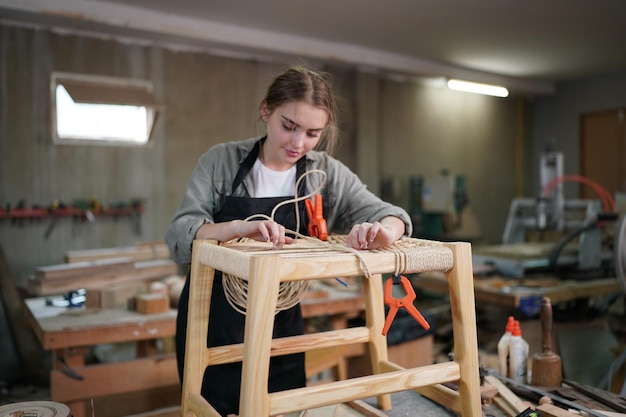 Small business of a young woman in furniture workshop background