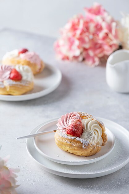 Photo small cakes with whipped cream and strawberry