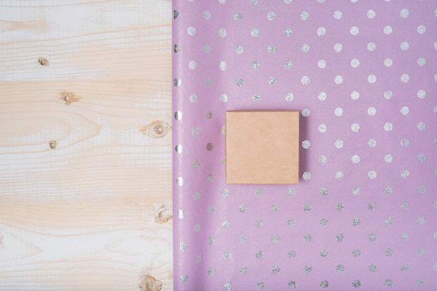 Small cardboard box and lilac polka dot wrapping paper. 