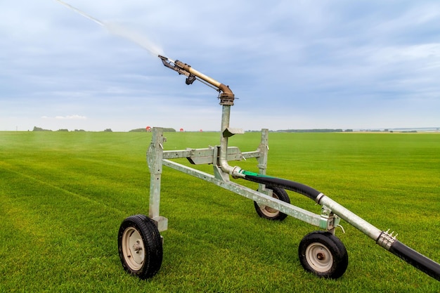 Photo a small cart with wheels that has a hose attached to it.