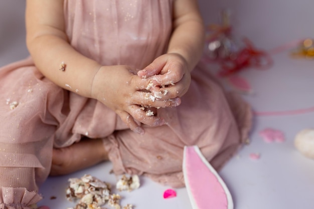 小さな子供が手でケーキの最初のケーキの 1 番を取り出します。誕生の最初の日。ケーキ