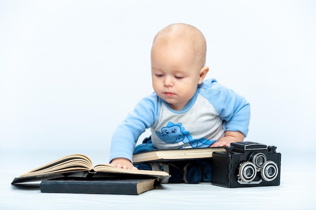 A small child and a camera on a neutral white background