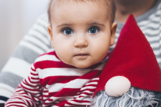 A small child at Christmas sits in dads arms with a dwarf