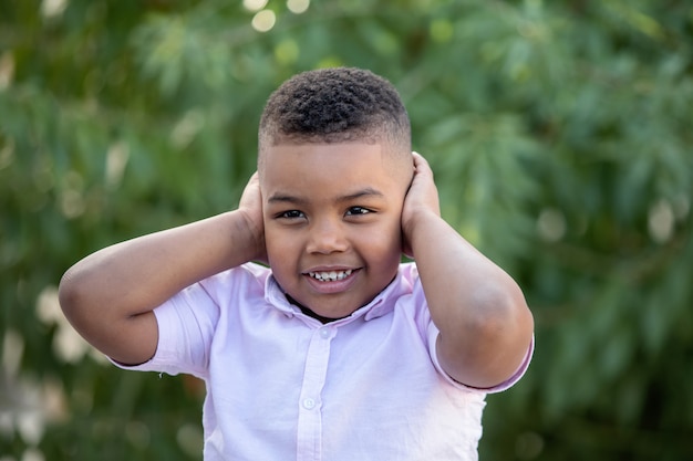 Photo small child covering his ears outside