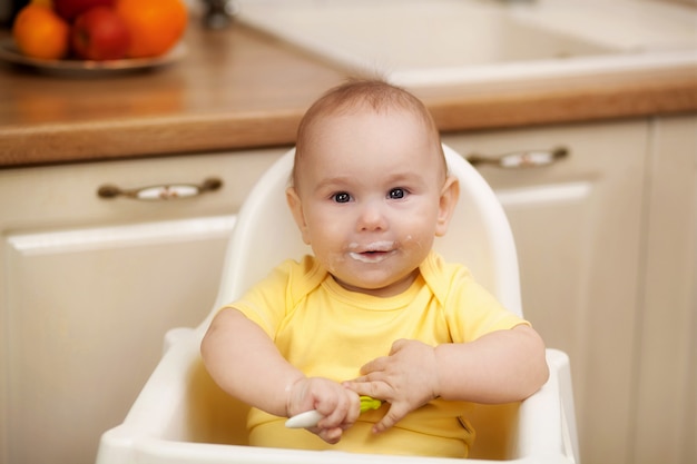 Small child in the feeding chair eats