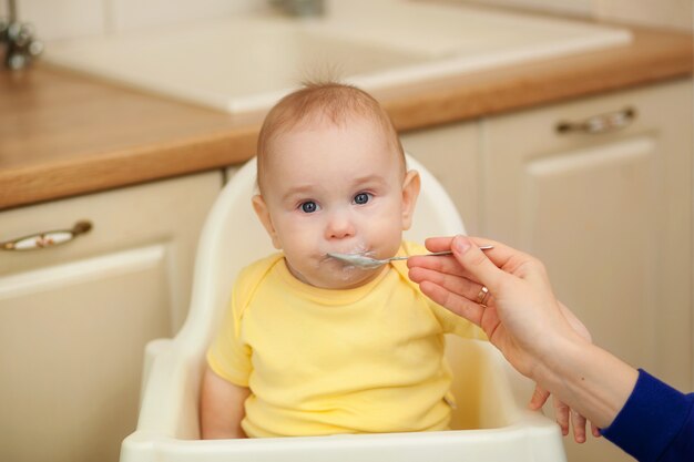 Small child in the feeding chair eats