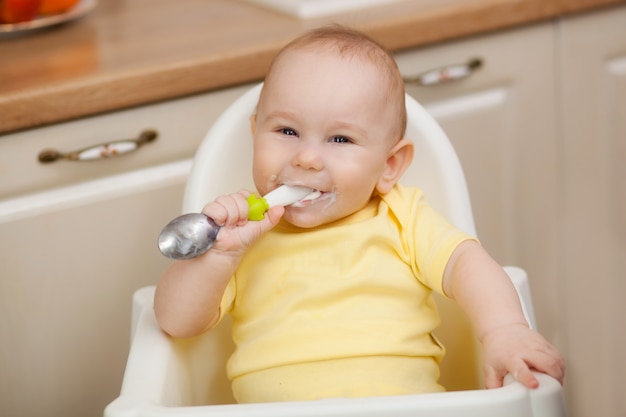 Small child in the feeding chair eats