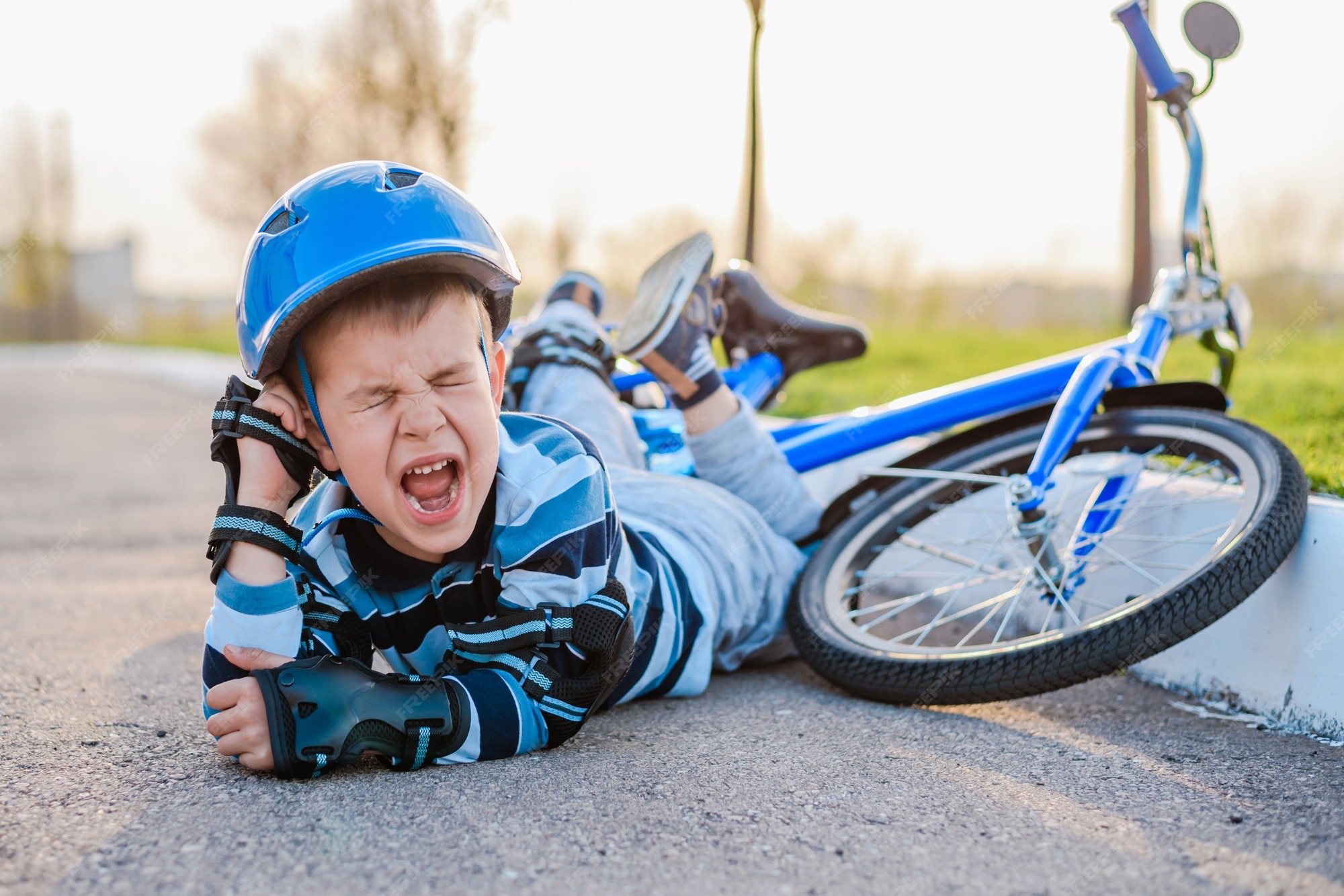 premium-photo-a-small-child-fell-from-a-bicycle-onto-the-road-crying
