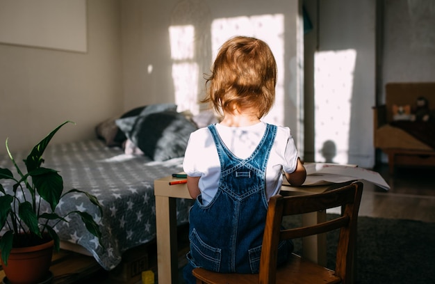 Small child at home at the children39s table draws with felttip\
pens