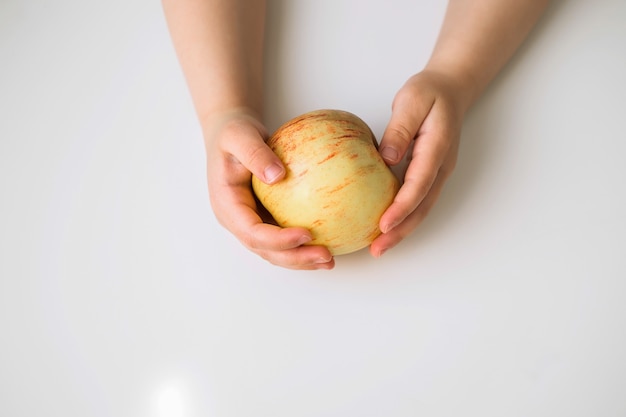 A small child is holding an apple