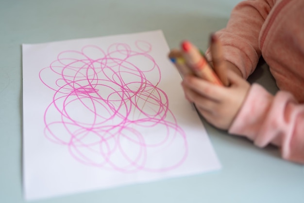 Маленький ребенок учится рисовать картинку