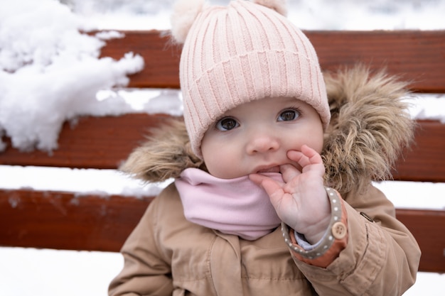 Un bambino piccolo è seduto sulla panchina.