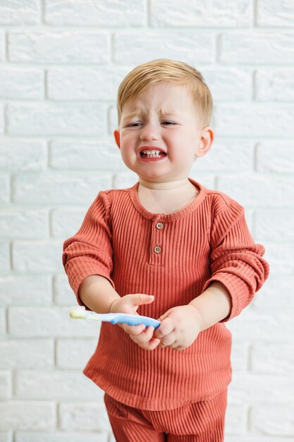 A small child learns to brush his teeth with a toothbrush. Dental hygiene in children