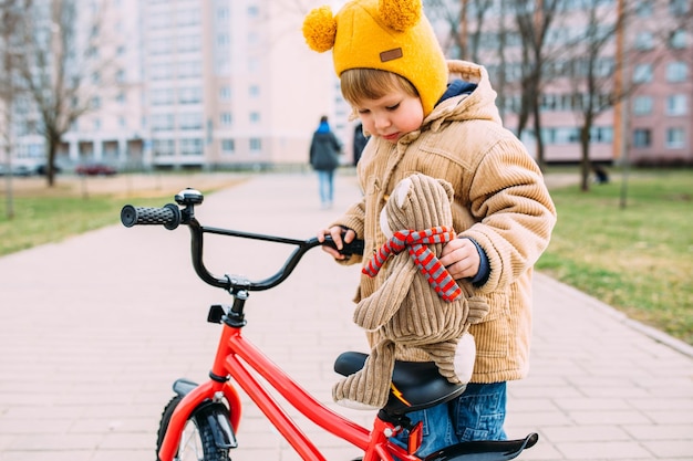 小さな子供が春に市内で初めて自転車に乗ることを学ぶ