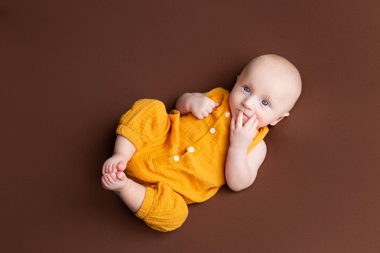 a small child lies on a brown background newborn boy babys first photo shoot