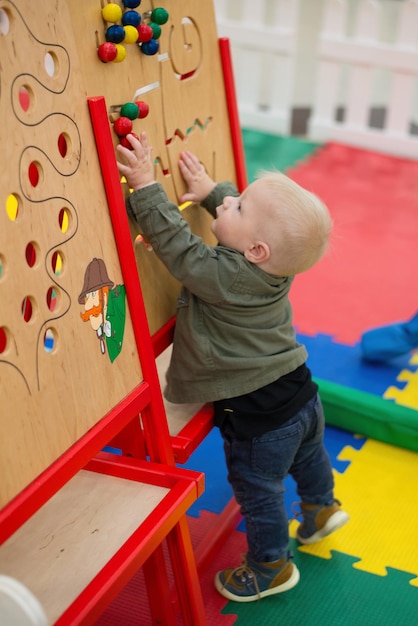 A small child occupies a childrens development center and plays while completing tasks