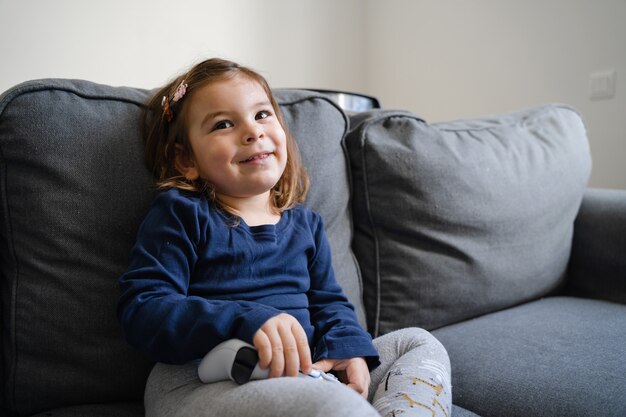 Small child playing video games with gamepad on console