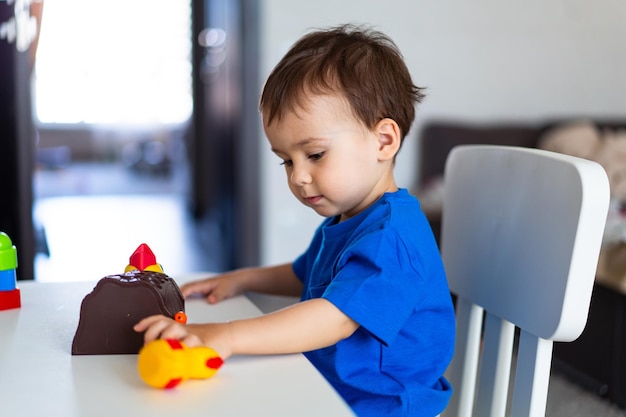 A small child playing with a toy at a table