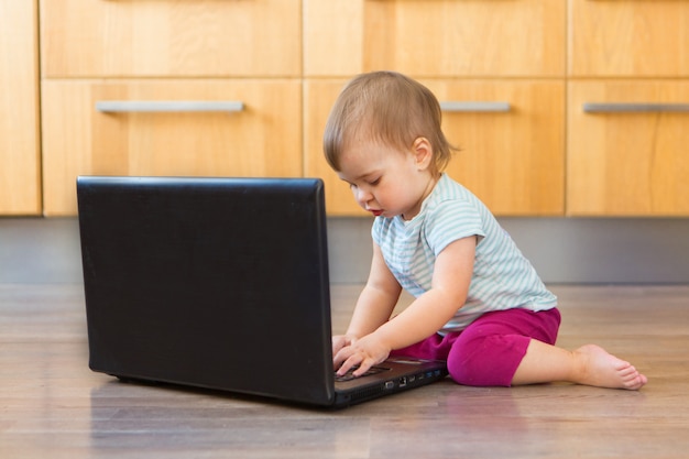 Small child plays on computer. The child Prodigy learns the techniques of business Planning, home work, quarantine, self-isolation, protection from coronavirus, virus, home education, distance work.