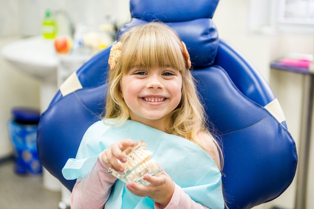 A small child plays with artificial jaws. Children's dentistry. Dental office.