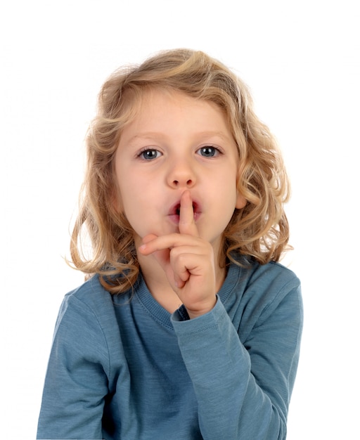 Small child putting forefinger to lips as sign of silence 