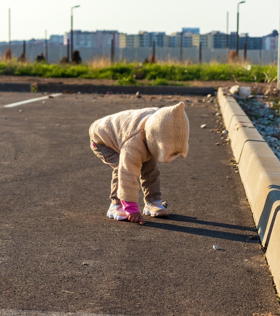 小さな子供が夕日に逆らって駐車場を走ります