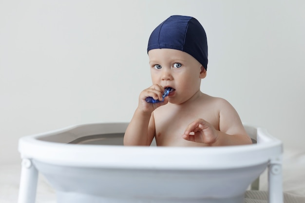 Un bambino piccolo si stringe i denti mentre è seduto in bagno