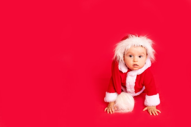 A small child in a Santa costume with copy space