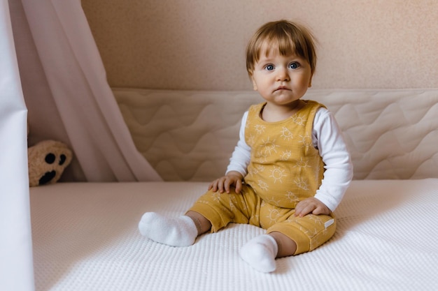 Small child sitting on the bed cut baby