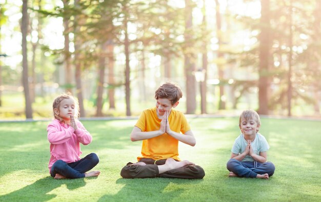 small children are trying to repeat the lotus position after their older brother